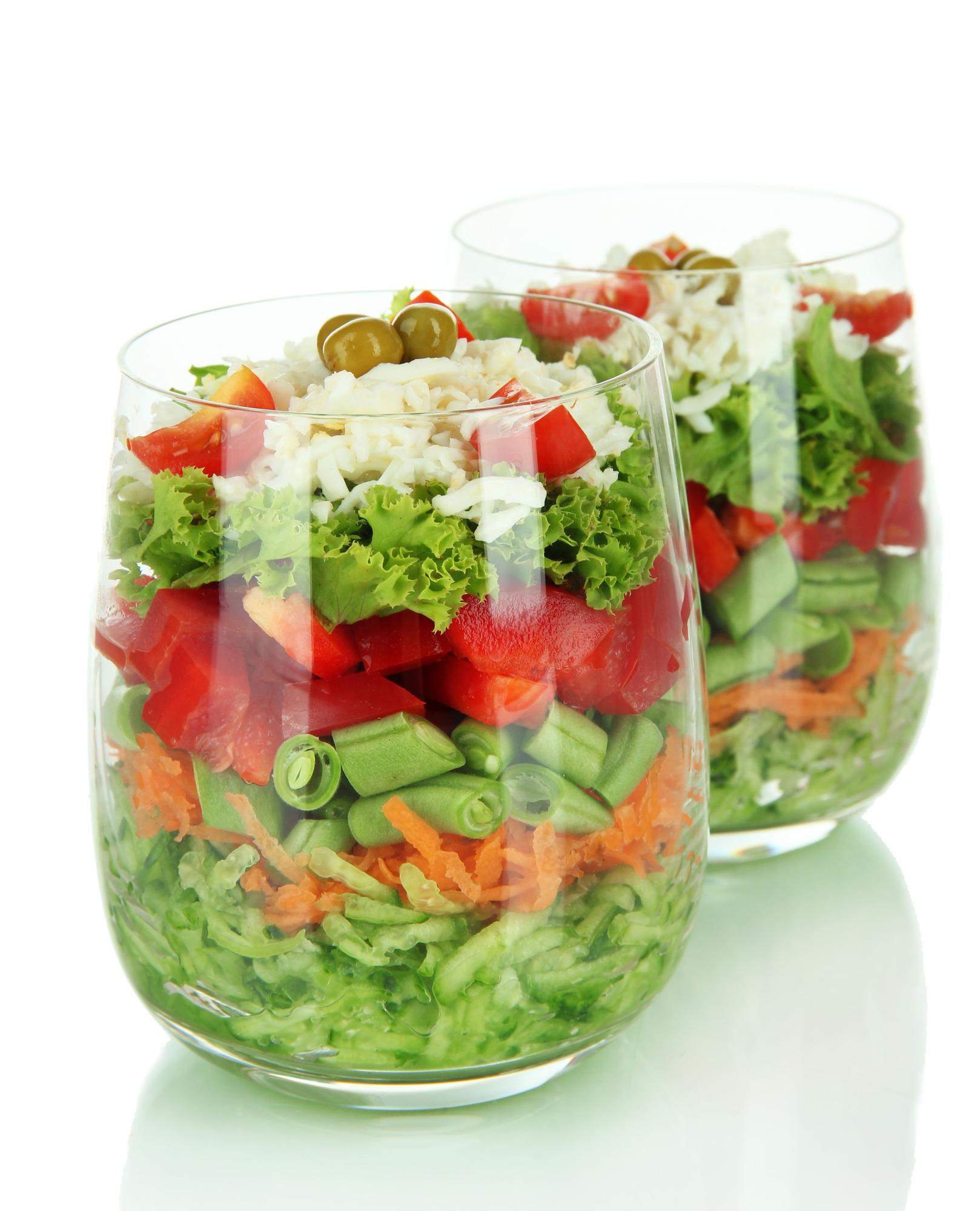 Stack of prepared salads in transparent bowls